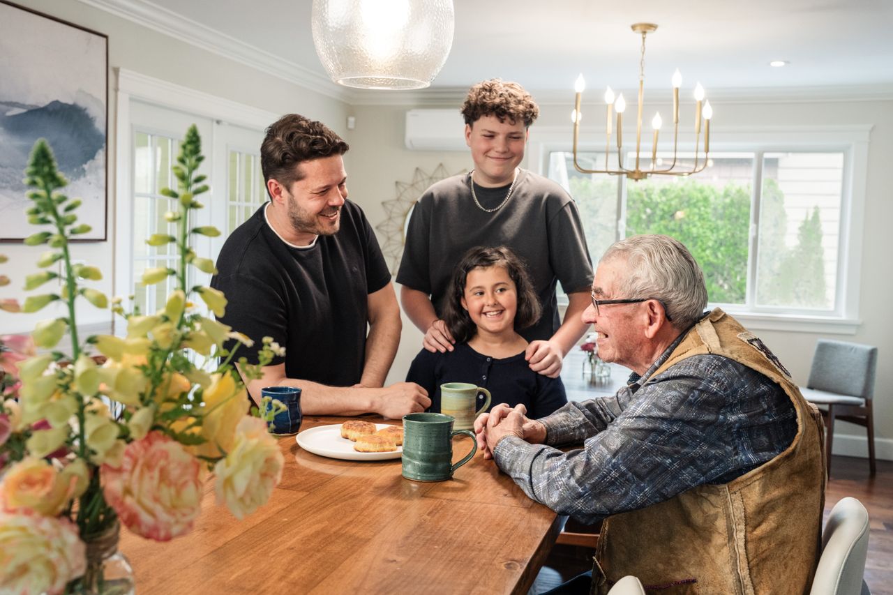 A joyful multigenerational family gathering around the kitchen table, sharing smiles and bonding.